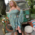 A woman wearing the green Hippie Bohemian Fairy Dress with Elastic Fairy Skirt in front of a vintage Volkswagen bus.