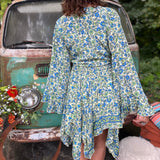 A woman wearing the green Hippie Bohemian Fairy Dress with Elastic Fairy Skirt in front of a vintage Volkswagen bus.