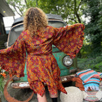 A woman wearing the red Hippie Bohemian Fairy Dress with Elastic Fairy Skirt in front of a vintage Volkswagen bus.