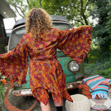 A woman wearing the red Hippie Bohemian Fairy Dress with Elastic Fairy Skirt in front of a vintage Volkswagen bus.