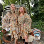 Two women wearing the orange and cream Hippie Bohemian Fairy Dress with Elastic Fairy Skirt in front of a vintage Volkswagen bus.