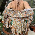 A woman wearing the orange and cream Hippie Bohemian Fairy Dress with Elastic Fairy Skirt in front of a vintage Volkswagen bus.