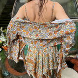 A woman wearing the orange and cream Hippie Bohemian Fairy Dress with Elastic Fairy Skirt in front of a vintage Volkswagen bus.