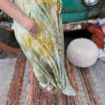 A woman wearing the green Hippie Bohemian Hand Dyed Palazzo Pants in front of a vintage Volkswagen bus.