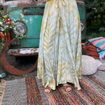 A woman wearing the green Hippie Bohemian Hand Dyed Palazzo Pants in front of a vintage Volkswagen bus.