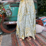 A woman wearing the green Hippie Bohemian Hand Dyed Palazzo Pants in front of a vintage Volkswagen bus.