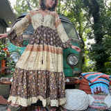 A woman wearing the Earthy Solstice Boho Bell Sleeve Maxi Dress in front of a vintage Volkswagen bus.