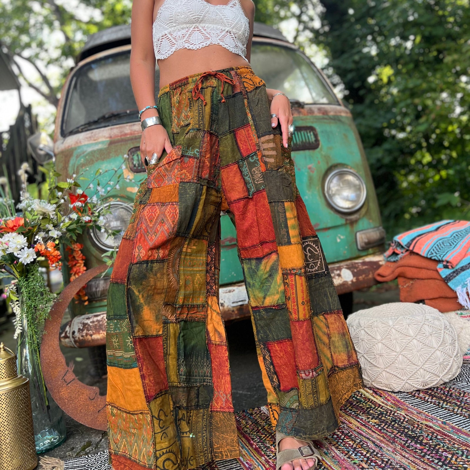 A woman wearing the Bohemian Patchwork Flare Wide Leg Pants in front of a vintage Volkswagen bus.