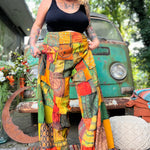 A woman wearing the Bohemian Patchwork Flare Wide Leg Pants in front of a vintage Volkswagen bus.