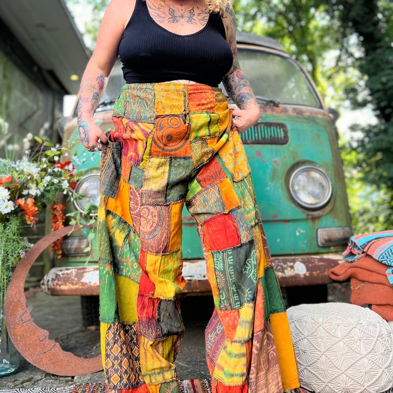 A woman wearing the Bohemian Patchwork Flare Wide Leg Pants in front of a vintage Volkswagen bus.