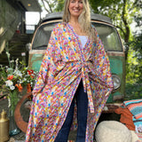 A woman wearing the Rainbow Hippie Boho Psychedelic Kimono Robe in front of a vintage Volkswagen bus.