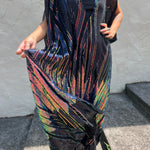 A woman wearing the Midnight Lotus Caftan with a black dress and heels.