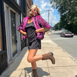 A woman wearing the Faux Fur Jacket in Monster Pink by Jennafer Grace with a black dress and brown boots.