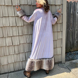 A woman wearing the Blush Velvet Faux Fur Jacket by Jennafer Grace with a black dress and brown boots.