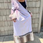 A woman wearing the Blush Velvet Faux Fur Jacket by Jennafer Grace with a black dress and brown boots.
