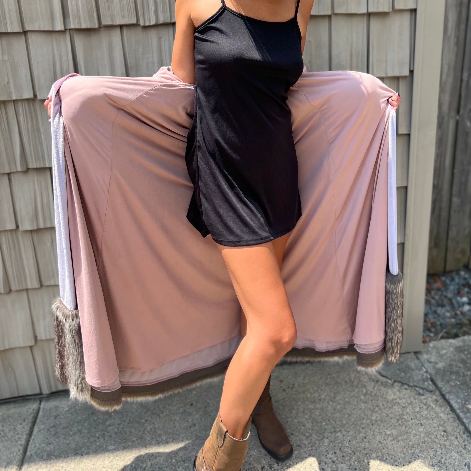 A woman wearing the Blush Velvet Faux Fur Jacket by Jennafer Grace with a black dress and brown boots.