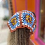 A woman wearing the Handmade Granny Square Crochet Headband around her head.