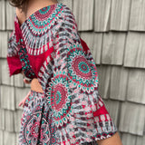 A woman wearing the pink Woven Floral Paisley Top and Trouser Set in front of a white wall.