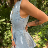 A woman wearing the Jeweled Button Denim Flare Cotton Dress oustide in front of some greenery.