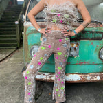 A woman wearing the beige Feather Crop Top with Stretch Flared Pants Set in front of a vintage teal Volkswagen bus.