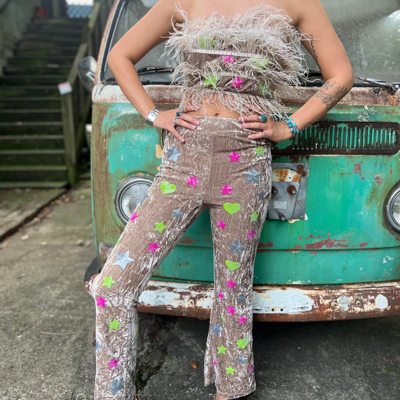 A woman wearing the beige Feather Crop Top with Stretch Flared Pants Set in front of a vintage teal Volkswagen bus.