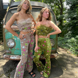 Two women wearing the beige and green Feather Crop Top with Stretch Flared Pants Set in front of a vintage teal Volkswagen bus.