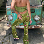 A woman wearing the moss green Feather Crop Top with Stretch Flared Pants Set in front of a vintage teal Volkswagen bus.