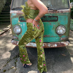 A woman wearing the moss green Feather Crop Top with Stretch Flared Pants Set in front of a vintage teal Volkswagen bus.