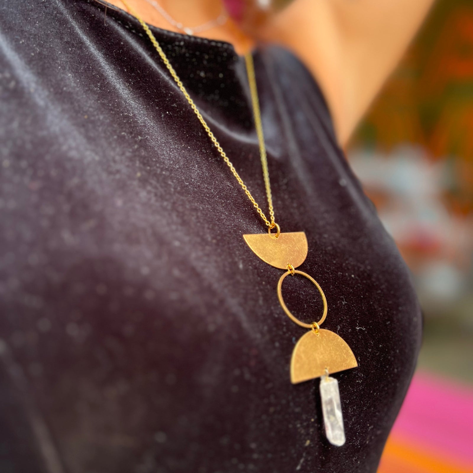 Someone wearing the Just a Phase Necklace with a black top.