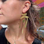 A woman wearing the Hammered Brass Summer Solstice 4 in. Earrings.