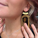 A woman wearing the Hammered Brass Summer Solstice 4 in. Earrings.