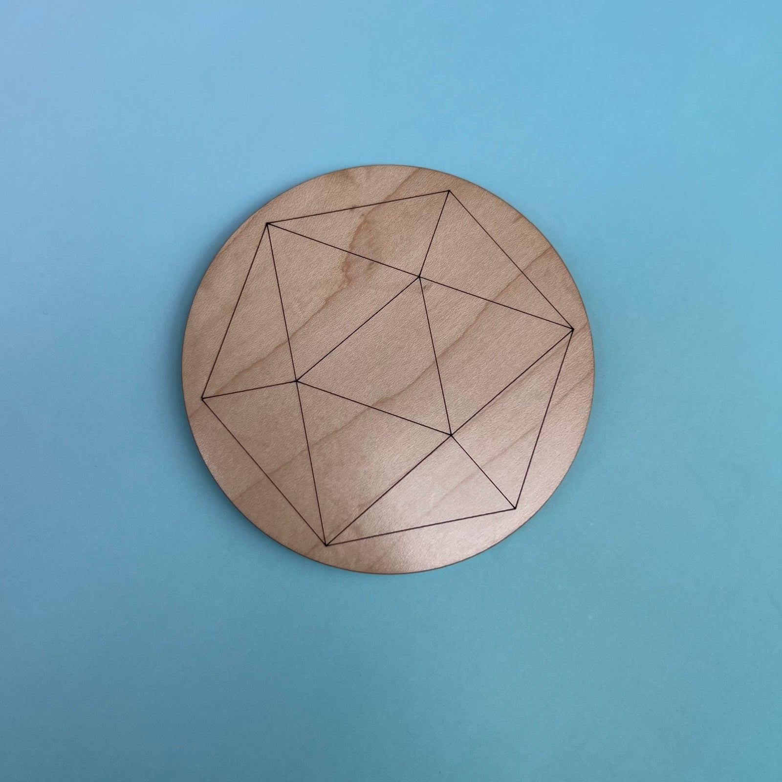 The Icosahedron 4 inch Wooden Crystal Grid on a light blue background.
