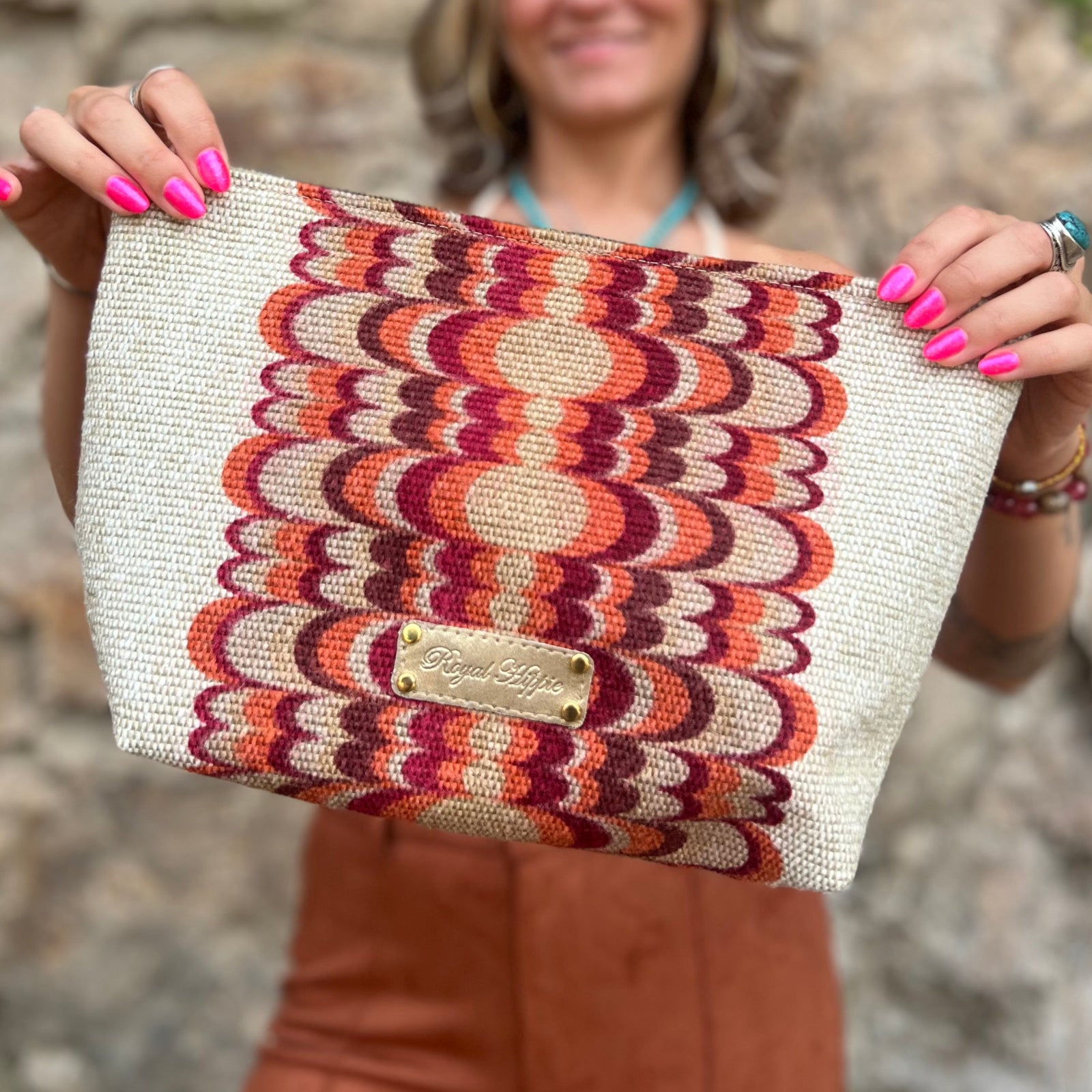 A woman holding out the Mid Century Modern Traveller Large Pouch.
