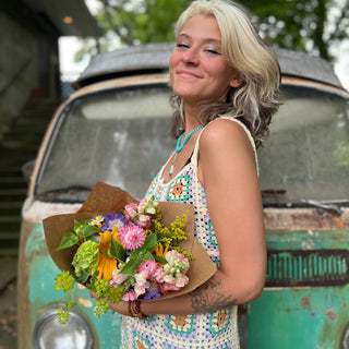 Someone wearing the beige Sleeveless Knit Tank Dress in front of an old teal Volkswagen bus.