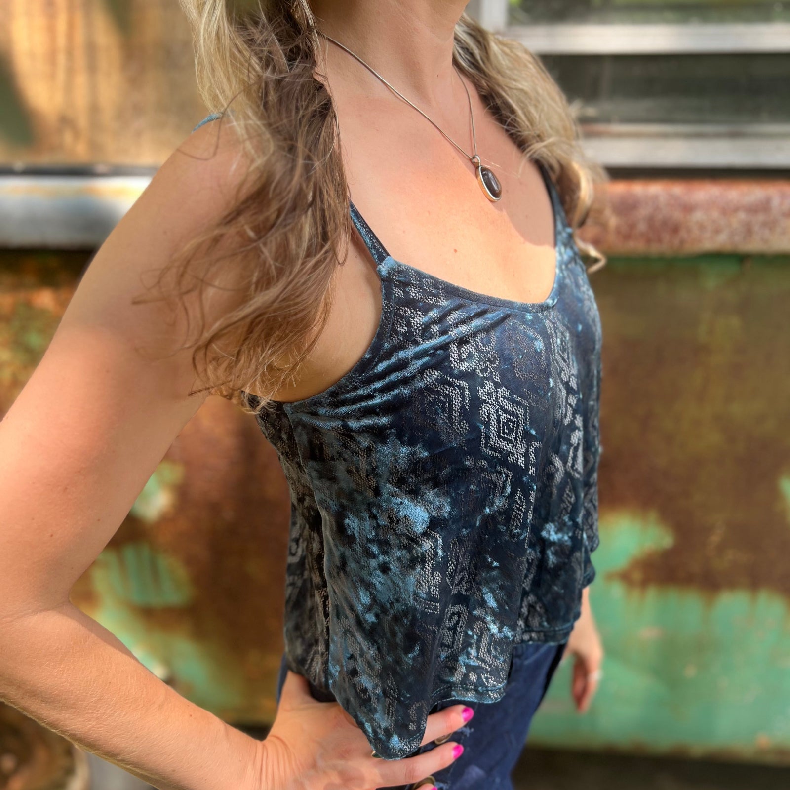 Someone wearing the Teal Spaghetti Strap Velvet Flowy Tank Top.