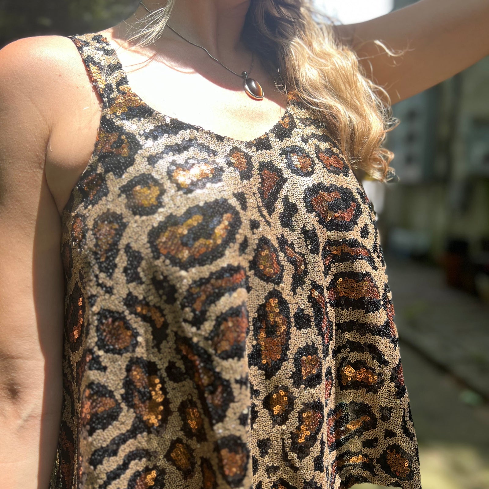 Someone wearing the Gold Cheetah Animal Print Flowy Sequin Tank.