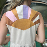 A woman wearing the cream Retro Sunburst Suede Color Block Long Fringe Faux Vest.