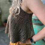 A woman wearing the Gold Spaghetti Strap Glitter Flowy Tank.