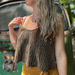A woman wearing the Gold Spaghetti Strap Glitter Flowy Tank.