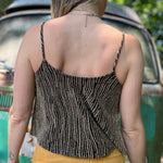 A woman wearing the Gold Spaghetti Strap Glitter Flowy Tank.