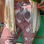 A woman wearing the Wine Western Paisley Print Fit & Flare Denim Jeans and cream fringe vest.