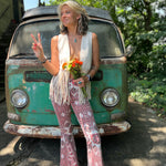 A woman wearing the Wine Western Paisley Print Fit & Flare Denim Jeans and cream fringe vest.