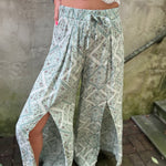 A woman wearing the Sage Linen Pants with Front Slit and a white bralette.