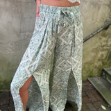 A woman wearing the Sage Linen Pants with Front Slit and a white bralette.