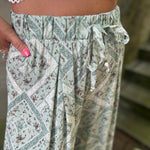 A woman wearing the Sage Linen Pants with Front Slit and a white bralette.