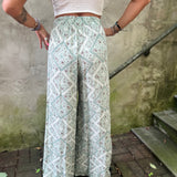 A woman wearing the Sage Linen Pants with Front Slit and a white bralette.