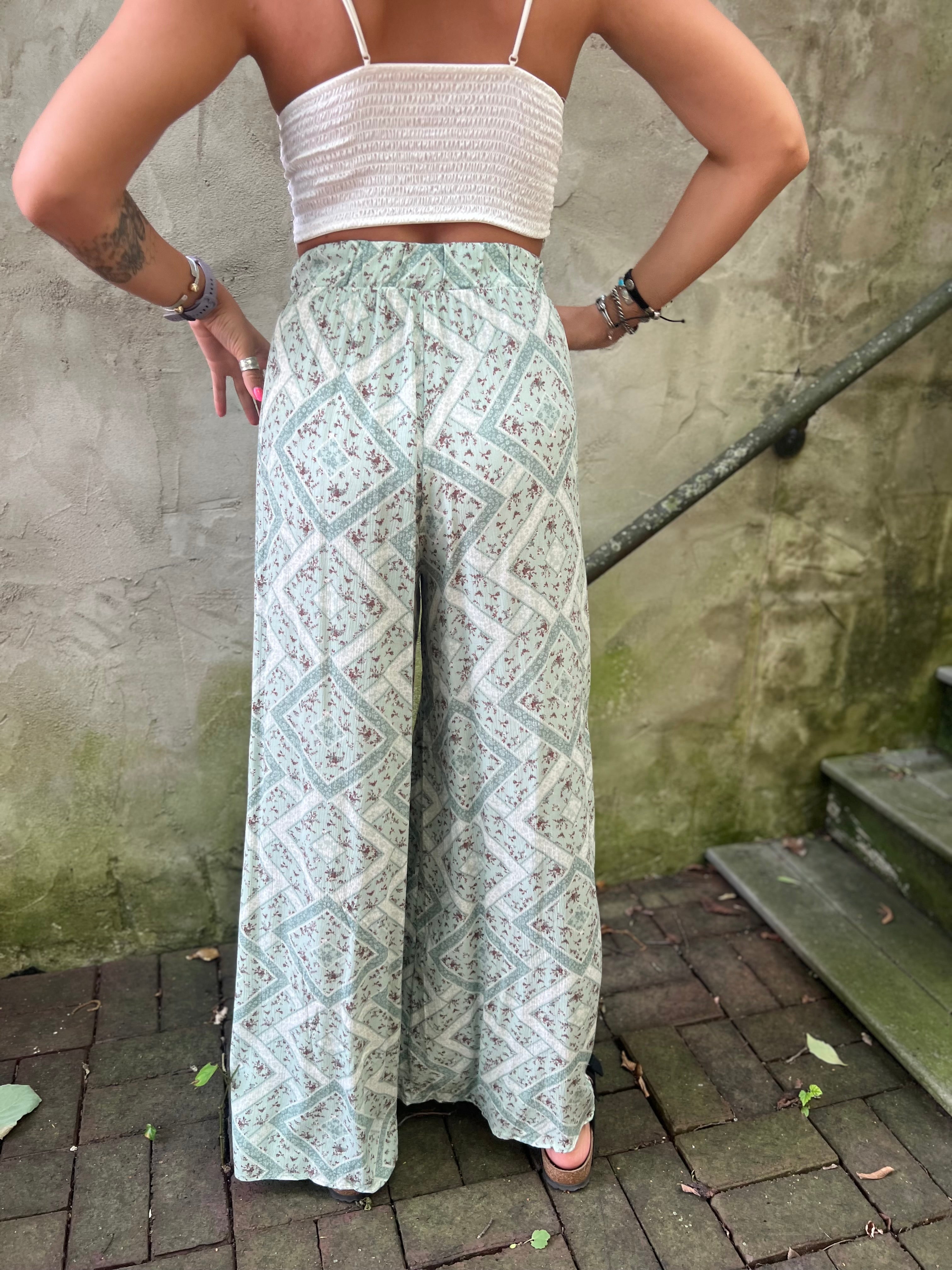 A woman wearing the Sage Linen Pants with Front Slit and a white bralette.