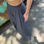 A woman wearing the Charcoal Ribbed Wide Leg Pants with Side Pockets with a cream crochet top.