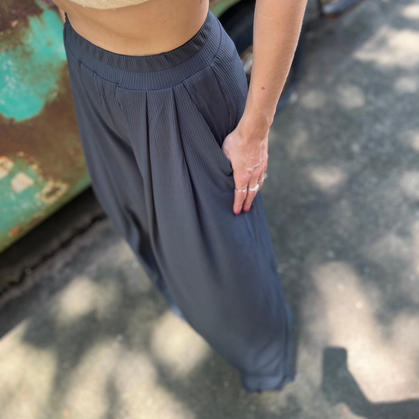 A woman wearing the Charcoal Ribbed Wide Leg Pants with Side Pockets with a cream crochet top.