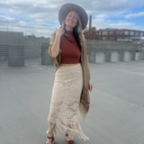 A woman wearing the Crochet-Knit Lace Fringe Maxi Skirt with a red top and a kimono.
